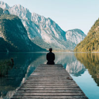 Future of healthcare - Man sitting on wood deck in front of a lake